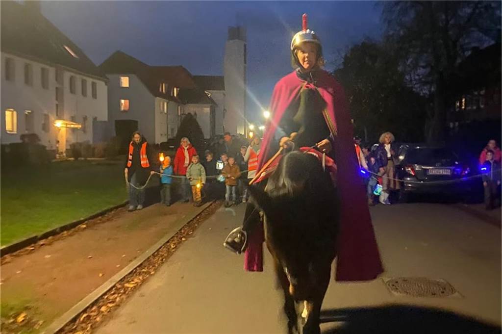 Martinsreiterinnen bedauern Abschaffung des Pferdes auf Umzügen Frau sitzt als St. Martin verkleidet auf einem Pferd und reitet vor einem Laternenumzug.