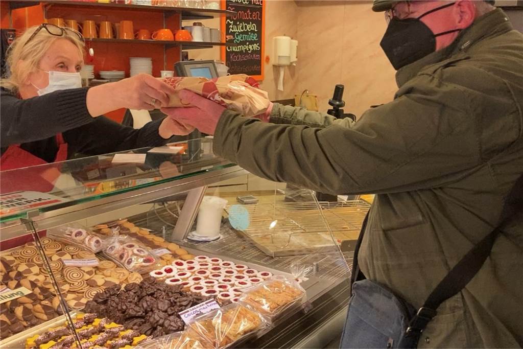 Steigende Preise: Kostet ein Brötchen bald 1 Euro? Annemarie Dahlmann reicht einem Kunden eine Tüte mit geschmierten Brötchen hinüber. Die müsste sie eigentlich inzwischen teurer verkaufen.