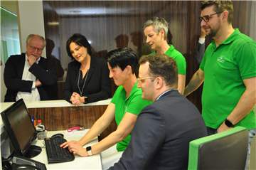 Annette Langenhorst (sitzend) und Martina Schmeddes zeigen Jens Spahn am praktischen Beispiel, wie die Fallakte funktioniert. Caritas-Vorstand Matthias Wittland (l.), Martina Schrage (2.v.l.) und Hausarzt Bernd Ballauf sind von der elektronischen Fallakte überzeugt.