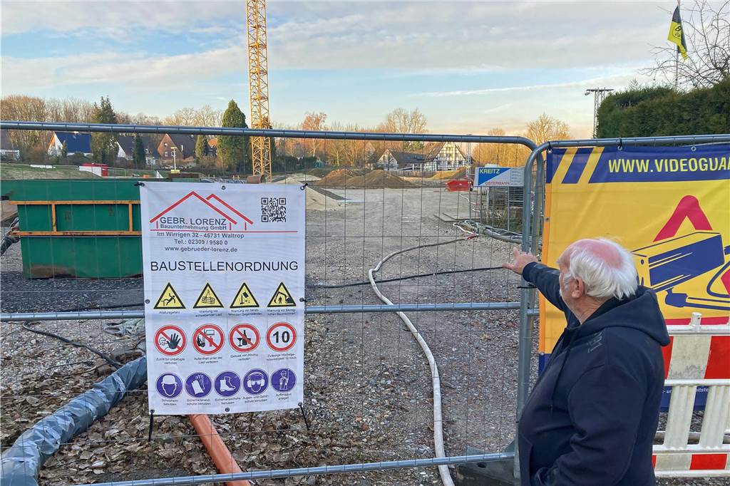 Umstrittenes Baugebiet Lennhofe: Ansichten gehen weiter auseinander Ein Mann steht vor dem Bauzaun zum Neubaugebiet "Am Lennhofe" in Dortmund-Menglinghausen. Er zeigt mit dem Finger auf das Gelände.
