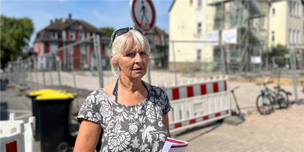 Baustelle an der Brüder-Grimm-Schule ruht: Wann ist der Erweiterungsbau fertig? Anwohnerin Sylvia Heger steht vor der Baustelle des Neubau der Brüder-Grimm-Schule an der Leostraße in Dortmund.