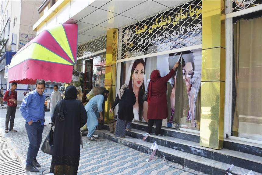 NRW will 1800 Flüchtlingen aus Afghanistan Schutz bieten – 1000 Plätze für Frauen Arbeiter in einem Schönheitssalon entfernen am 15. August 2021 in Kabul große Fotos von Frauen von der Wand, nachdem die Taliban in die afghanische Hauptstadt eingedrungen sind.