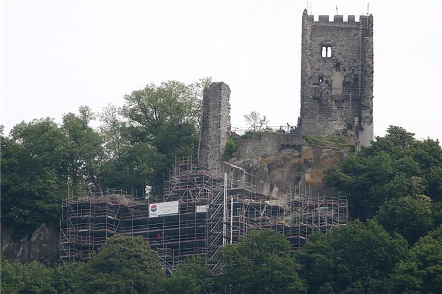 Der Drachenfels bröckelt: Sanierung soll Gestein retten Arbeiter setzen unterhalb der Burgruine Anker, um einen Felssturz zu vermeiden. Foto: Oliver Berg