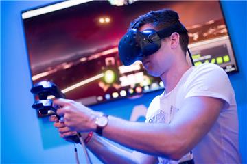 ARCHIV - Ein Besucher testet am 18.08.2016 auf der Spielemesse Gamescom in Köln (Nordrhein-Westfalen) eine VR-Brille vom Typ "Vive" des Herstellers HTC. (zu dpa: «Einmal durchbuchstabiert, was auf Köln zukommt: G-A-M-E-S-C-O-M» vom 20.08.2017) Foto: Marius Becker/dpa +++(c) dpa - Bildfunk+++