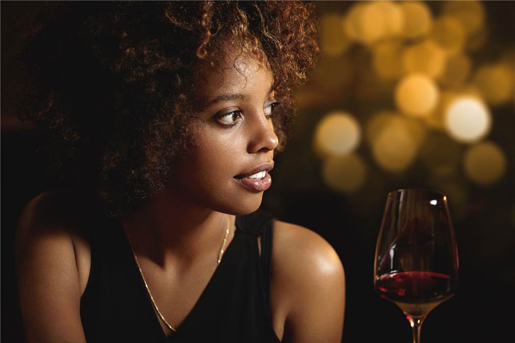 Silvester 2022 in NRW: Konfetti, Cocktails und Clubkultur schick angezogene frau mit rotwein in der hand