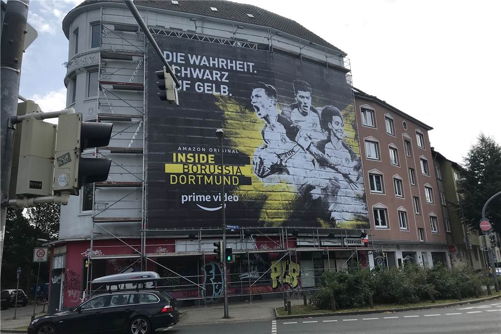 „Inside Borussia Dortmund“-Werbung finanziert zehn Hauseigentümern die Fassadenrenovierung Auch an dem leerstehenden Haus an der Weißenburger Straße hängt ein solches Gerüst. PoolOne beteiligt sich dafür finanziell an der Renovierung der Fassade.