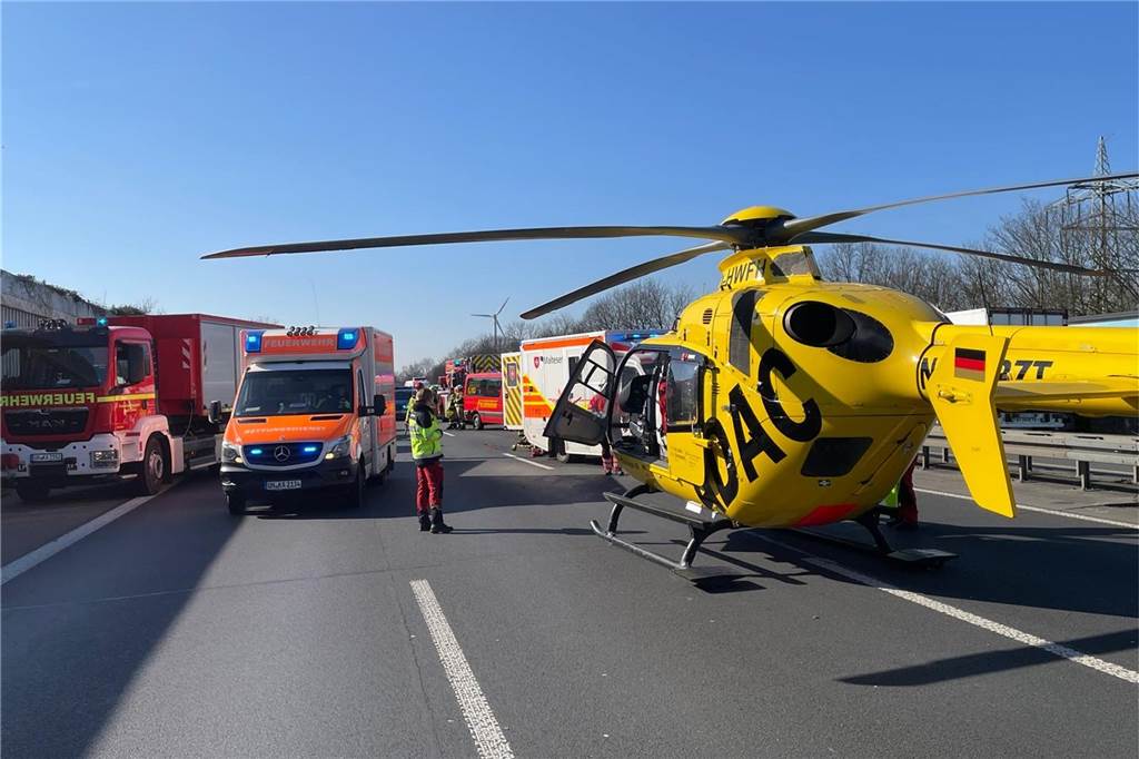 Ein Rettungshubschrauber steht nahe dem Kamener Kreuz, daneben stehen Einsatzkräfte.