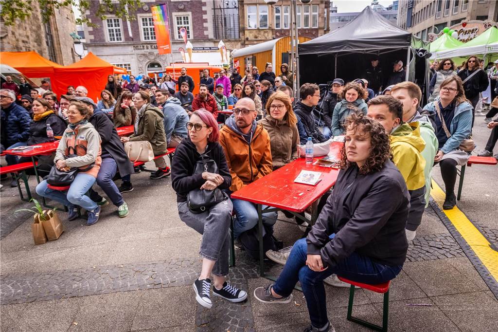 Menschen sitzen auf einer Bank.