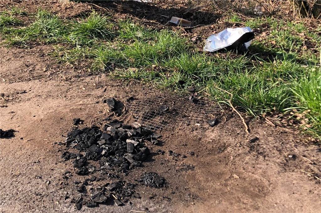 Ärger über Grillparty im Rhader Naturschutzgebiet: „Lasst das sein“ Abgebrannte Grillkohle, ein Grillrost und Müll am Wegesrand
