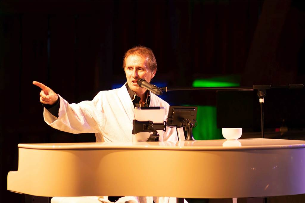 Udo singt Udos Lieder: Udo-Jürgens-Konzert in Erle Udo Hottens sitzt in einem Bademantel hinter einem weißen Flügel.