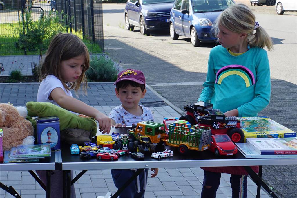 Dorftrödelmarkt lockt Schnäppchenjäger - auch Delfine spielen eine Rolle Kinder spielen an einem Stand.