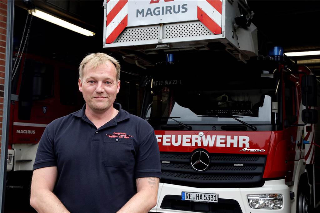 Ein Feuerwehrmann steht vor einem Einsatzfahrzeug