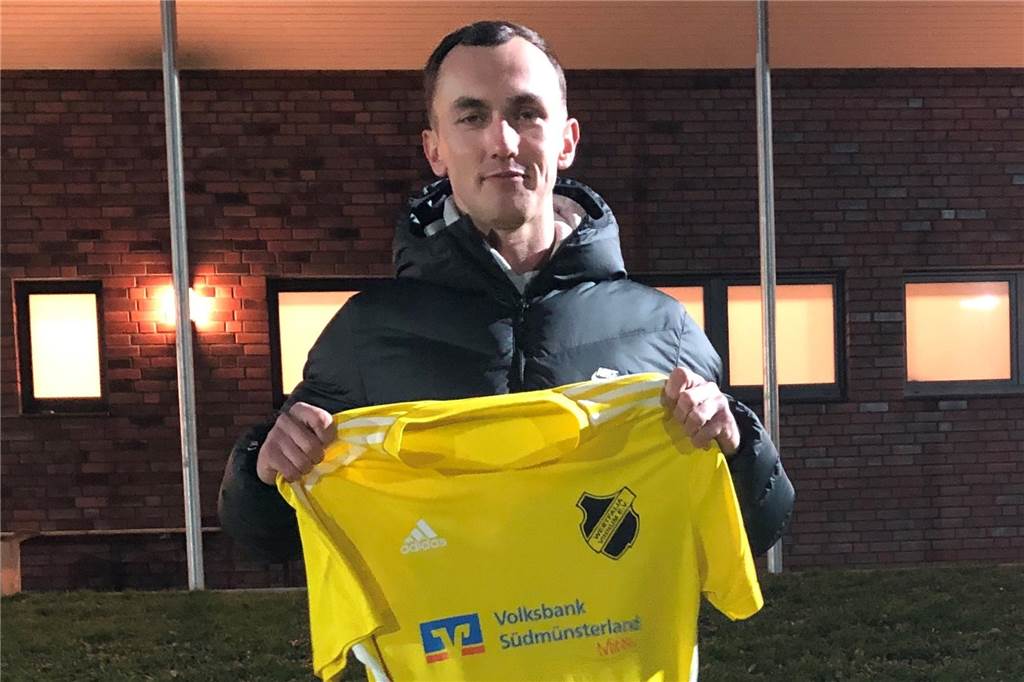 Dustin Nowak hält ein Trikot von Westfalia Vinnum in die Kamera.
