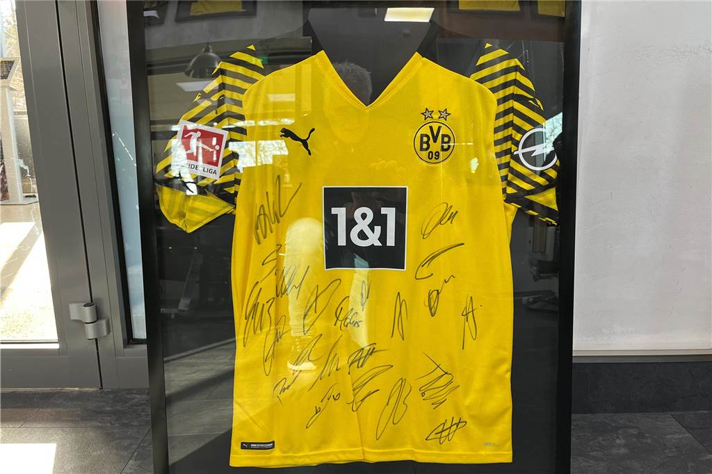 Friseur verlost BVB-Artikel gegen eine Spende für Kinder in Not Auch ein Trikot, das die BVB-Spieler signiert haben, gehört zu den Dingen, die bei der Spenden-Tombola zu gewinnen sind