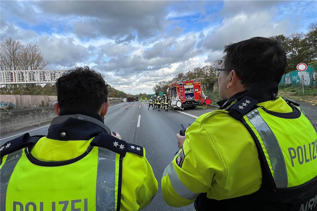 Nach dem Unfall auf der A1: Wer zahlt und was droht dem Fahrer? Zwei Einsatzkräfte der Polizei Unna betrachteten den umgekippten Gefahrguttransporter auf der A1 aus sicherer Entfernung per Kameradrohne.