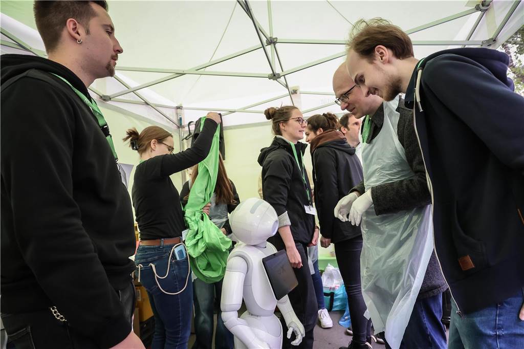 Menschen interagieren mit einem Roboter.