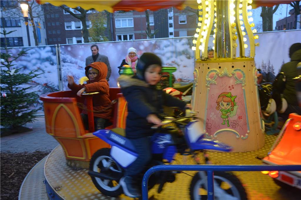 Zwei kleine Kinder fahren in einem Karussell. 