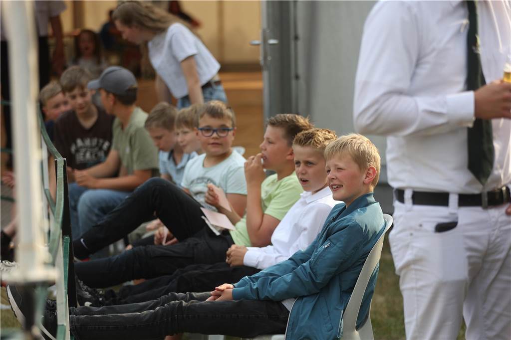 Mehrere Kinder sitzen in einer Reihe. 