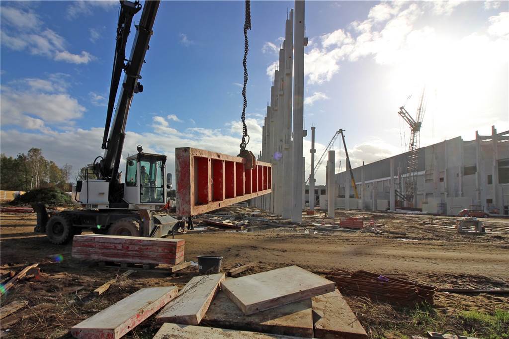 Rohbau von Levi's steht: Jeans-Riese baut riesig und nachhaltig Kleiner Kran mit Bauteil auf Baustelle Levi's in Dorsten