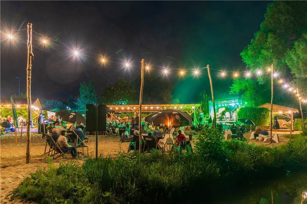 Auf dem Foto sieht man einen Biergarten am Abend.
