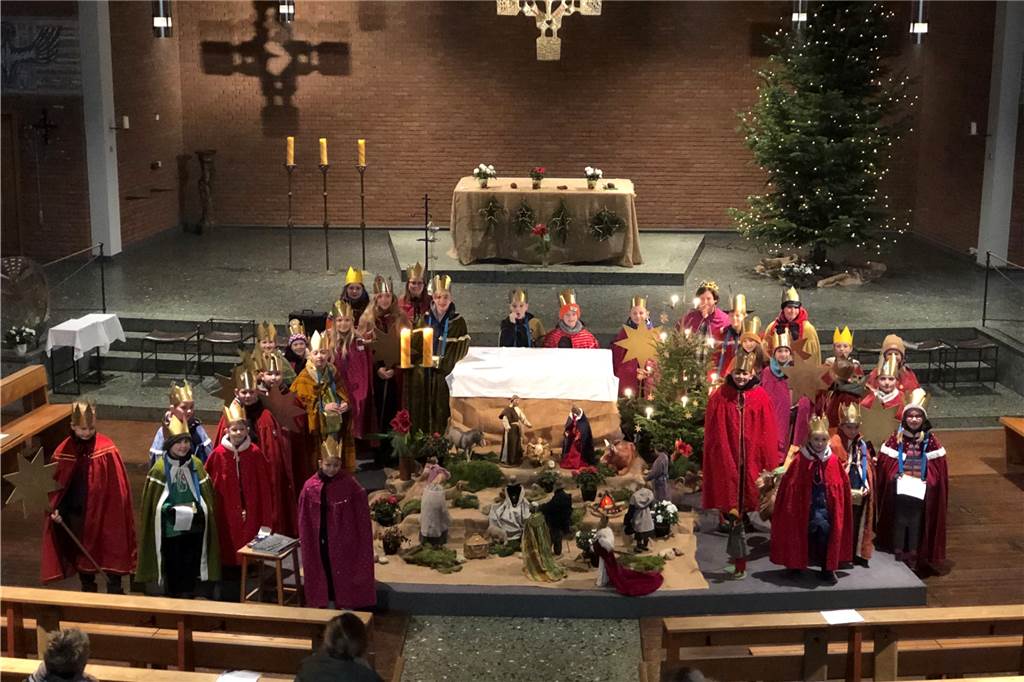 Die Sternsinger stehen rund um die Krippe in der St. Bonifatius Kirche.