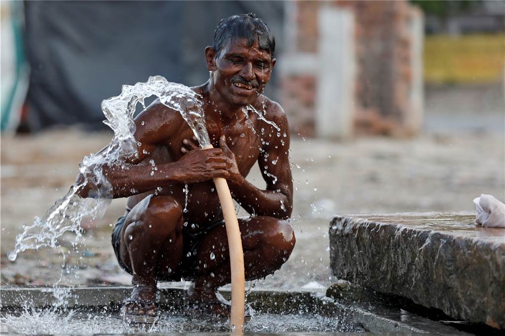 Wassernebel und weißer Asphalt: Was wir von heißen Metropolen lernen können Auch in Indien gibt es öffentliche Wasserhähne, in den die Menschen sogar baden.