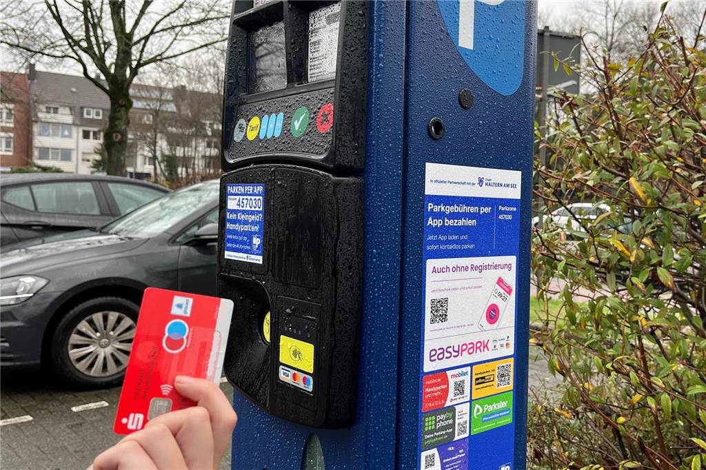 Bei der Park-App ruckelt es noch: „Parkster“ räumt interne Fehler ein Eine EC-Karte wird vor einen Parkautomaten gehalten.