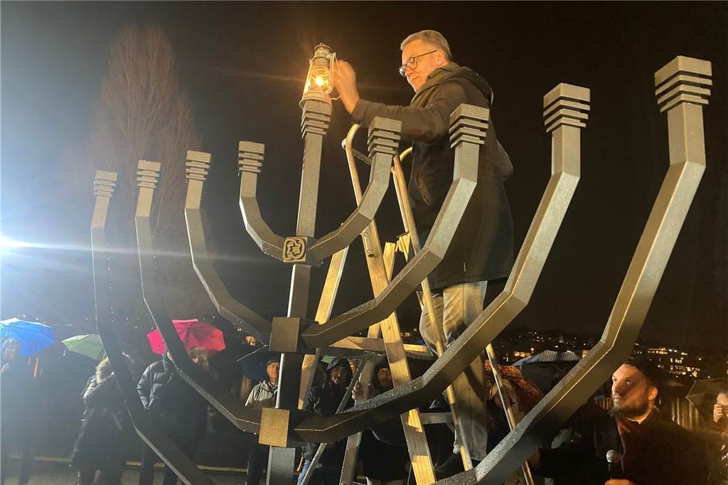 Auch Oberbürgermeister Thomas Westphal gehörte zu den Ehrengästen, die ein Licht am Chanukka-Leuchter auf der Kulturinsel im Phoenix-See entzünden durften - hier assistiert von Rabbiner Avigdor Moshe Nosikov.