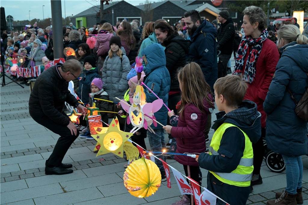 Hinter einem Absperrband auf dem Campus in Selm stehen Kinder. Der Bürgermeister Thomas Orlowski beugt sich zu ihnen hinunter und spricht mit ihnen. 