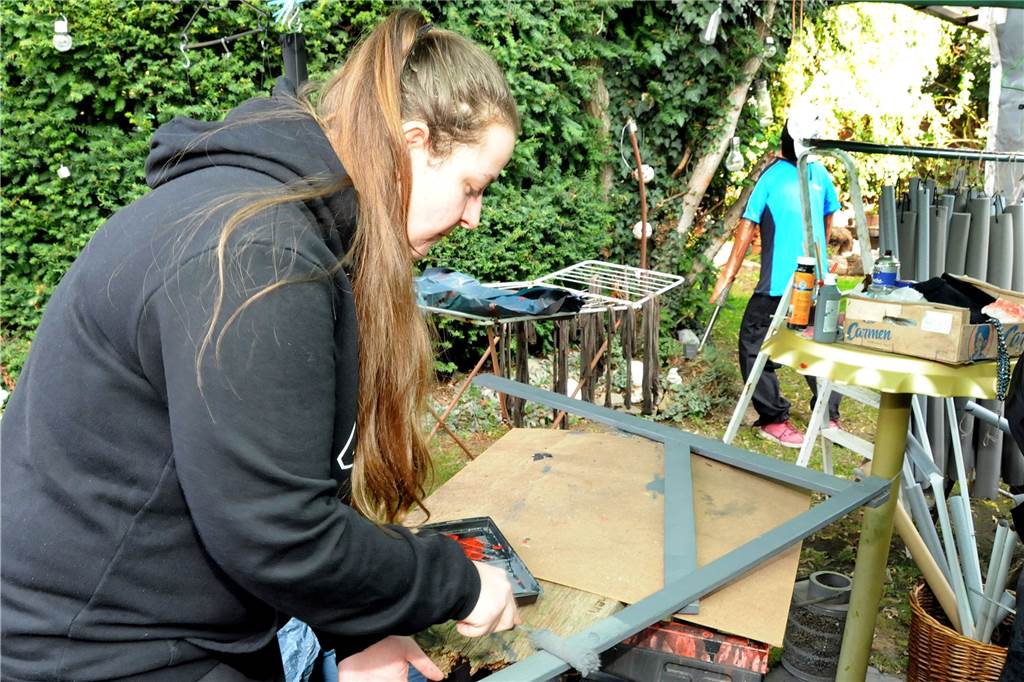 Skelett am Spieß: Das Horror-Haus von Geisecke trotzt der Energiekrise Auch Tochter Justine Schneider hilft tatkräftig mit bei der Gestaltung des Horrorgartens in Geisecke. Hier streicht sie den Galgen, an dem später die Figur eines Paketboten zappeln soll.