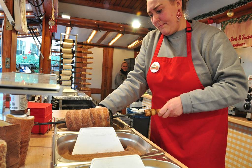 Jenseits der Bratwurst: Kulinarische Tipps für den Dortmunder Weihnachtsmarkt Auf das karamellisierte, heiße Zucker kommen Kakao Kokos und mehr: Chanela Hoster bereitet Baumstriezel zu