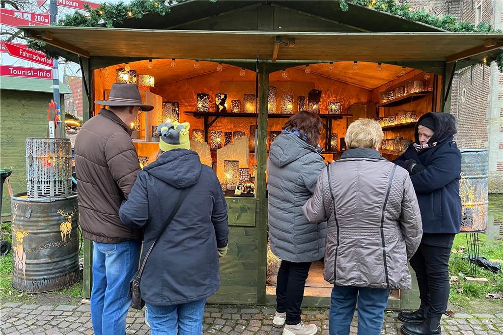 Ein paar Menschen stehen vor einem Stand, der Lichterhüllen verkauft.