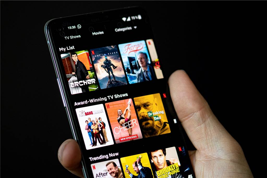 Auf dem Bildschirm eines Smartphones sieht man in der App von Netflix das Filmangebot des Streaminganbieters. 