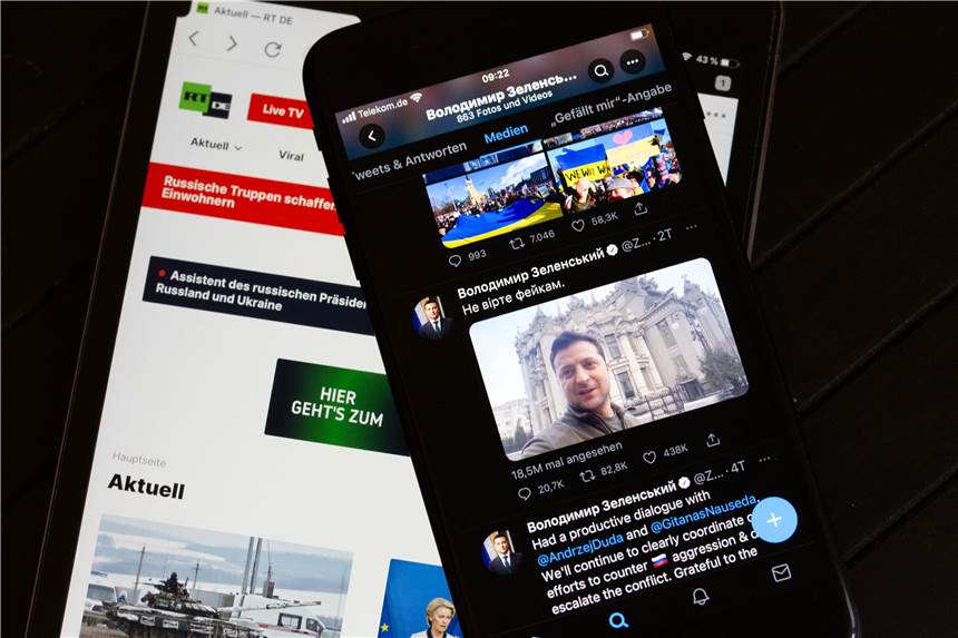 Fake News zum Ukraine-Krieg: Wie unterscheidet man echte Inhalte von falschen? Auf dem Bildschirm eines Tablets (l) ist die Website des russischen Fernsehsenders RT zu sehen, rechts auf dem Bildschirm der offizieller Twitter-Account des ukrainischen Präsidenten Selenskyj.