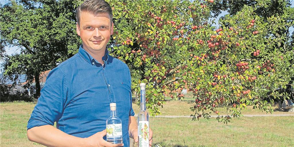 Landwirt Tobias Dalhaus aus Dorsten pendelt zwischen Hof und Hörsaal Ein Mann steht vor einem Apfelbaum und hält zwei Flaschen.