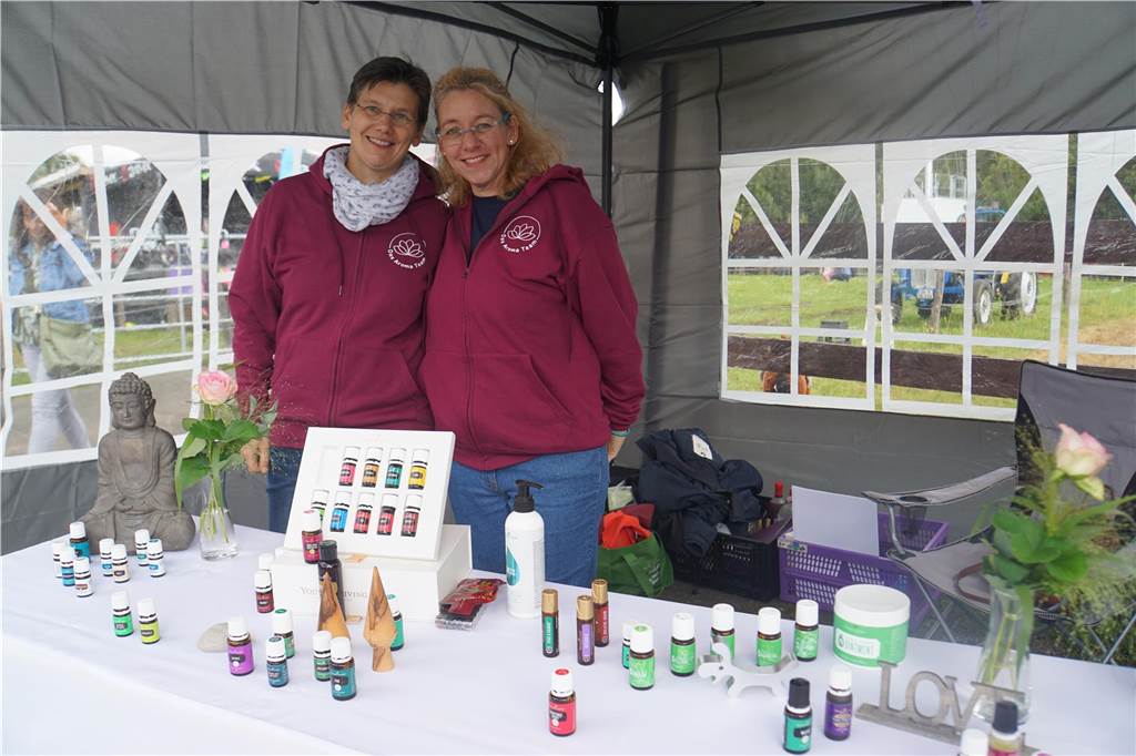 Zwei Frauen posieren für ein Foto an ihrem Stand. 