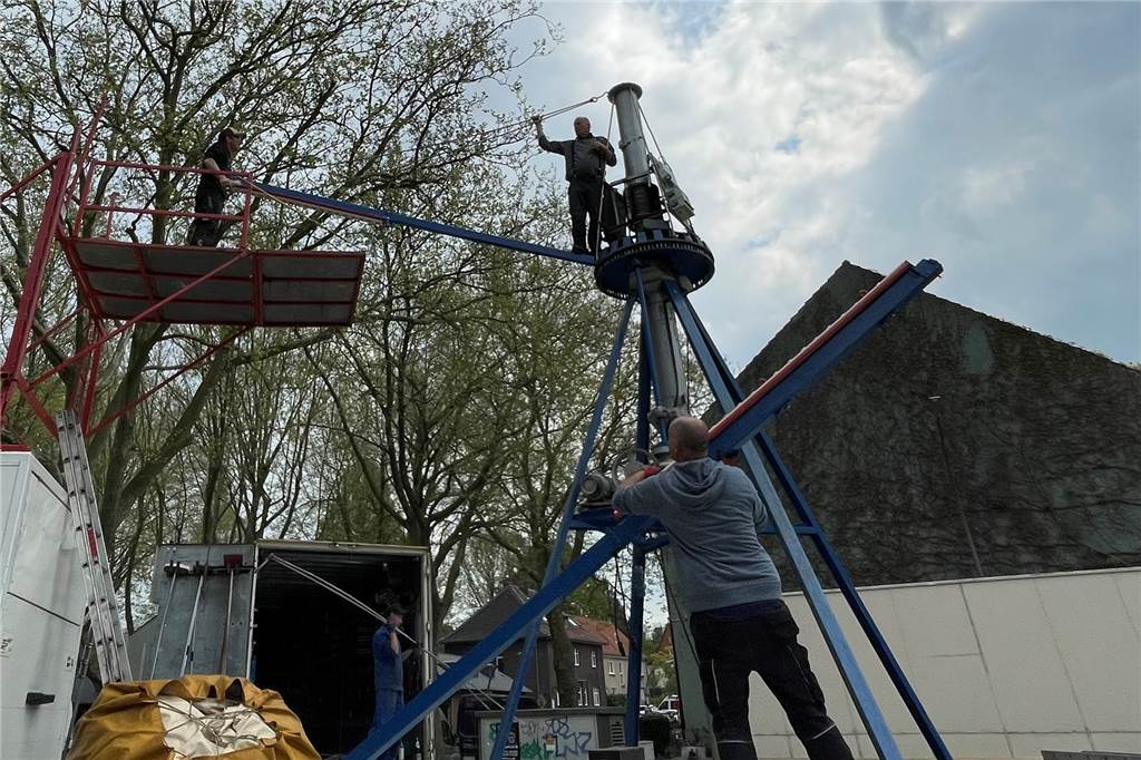 Schausteller zu Kirmes: „Gibt Kinder, die haben das Karussell noch nie gesehen“ Auf dem Parkplatz am Stadtgarten bauen Männer das nostalgische Kettenkarussell "Schwanenflug" auf.