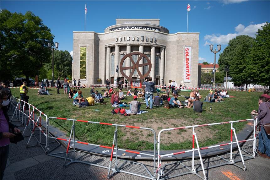 Auf dem Rosa-Luxemburg-Platz in Berlin sitzen Menschen bei einer Demonstration dem Rasen vor dem Volksbühne Theater. (Archivfoto)