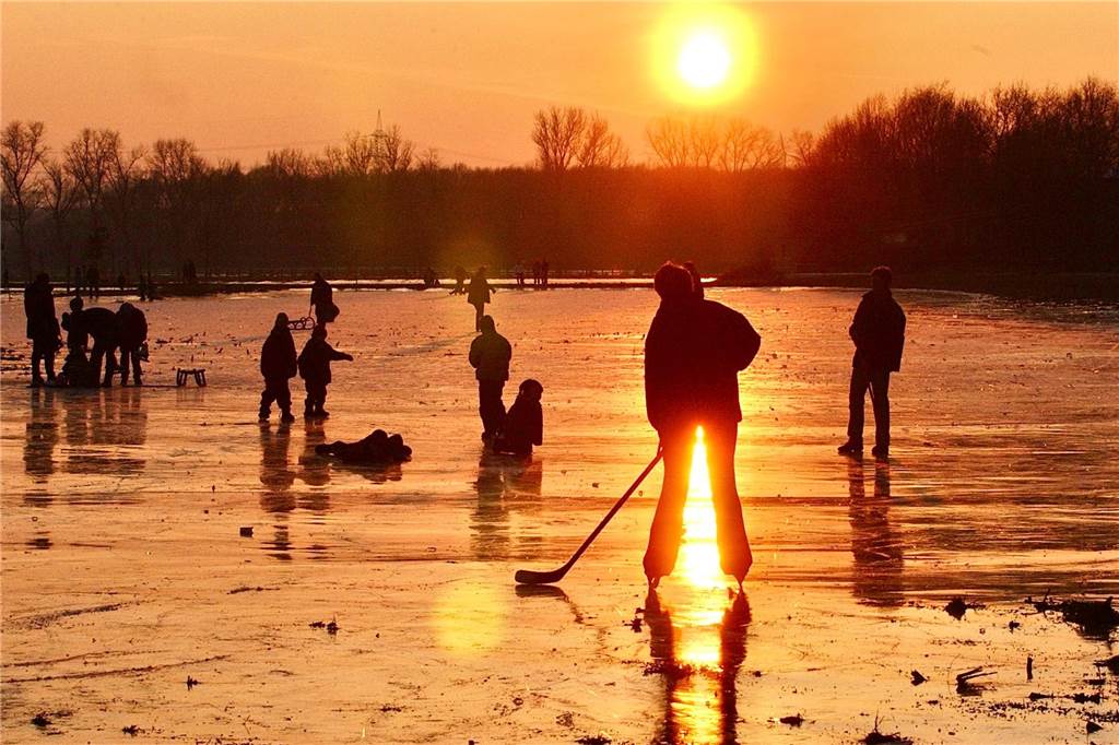 Erinnerungen an ein „Jahrhundert-Hochwasser“: Jetzt ist der Pegel in Dorsten höher als 2003 Schlittschuhläufer in der Abendsonne auf zugefrorener Wiese in Dorsten