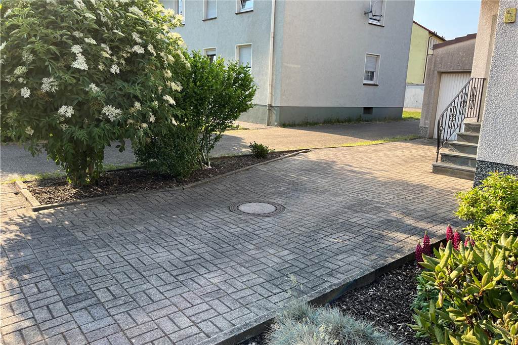 So verändert sich das Leben durch die Zeltstadt in Bork Die Einfahrt, auf dem sich die Belästigung ereignete. Links steht ein Beet mit zwei größeren Pflanzen.