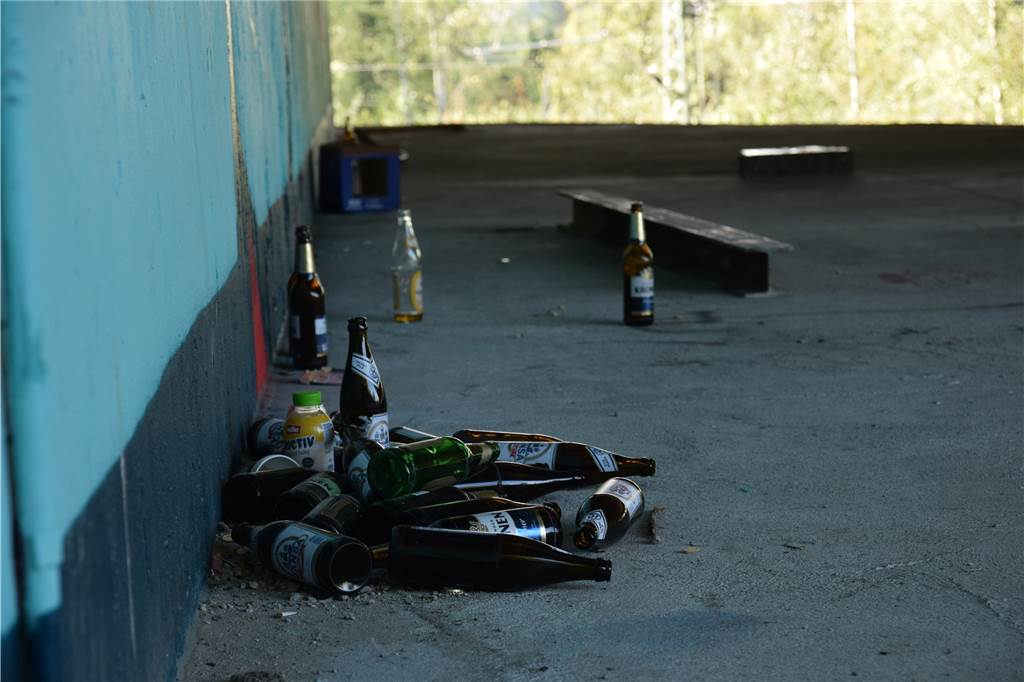 Auf der Plattform unter der A40 in Dormtund liegen viele gläserne Bierflaschen. 
