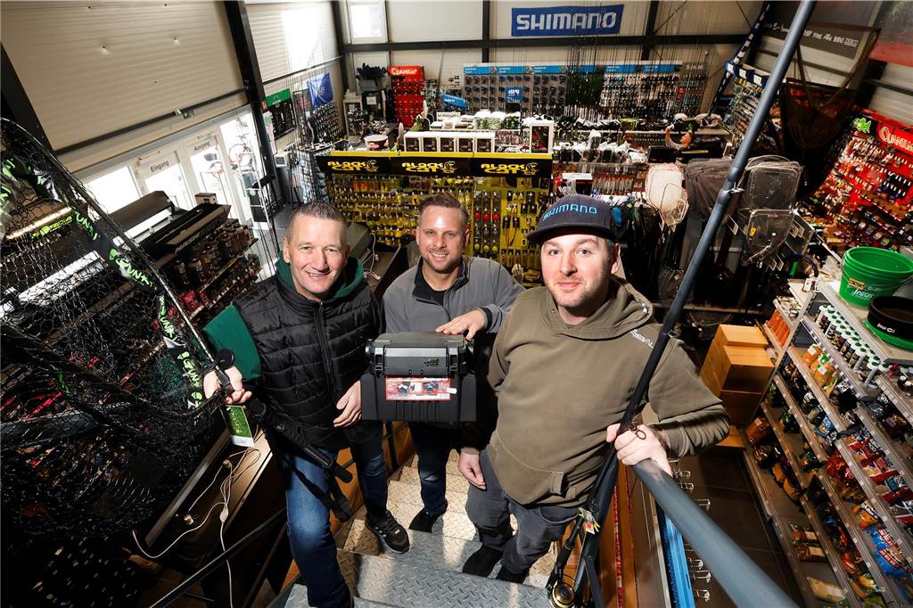 Auf der Treppe zum Lager stehen (v.l.) Jürgen Willig, Kai Malzahn und Tobias Peske. Im Erdgeschoss halten sie 12.000 unterschiedliche Produkte fürs Profiangeln vor.