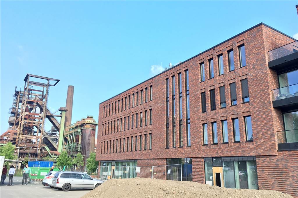 Auf der Vorderseite des Gebäudes entsteht eine große Terrasse. Der Parkplatz wird durch eine Grünfläche ersetzt.