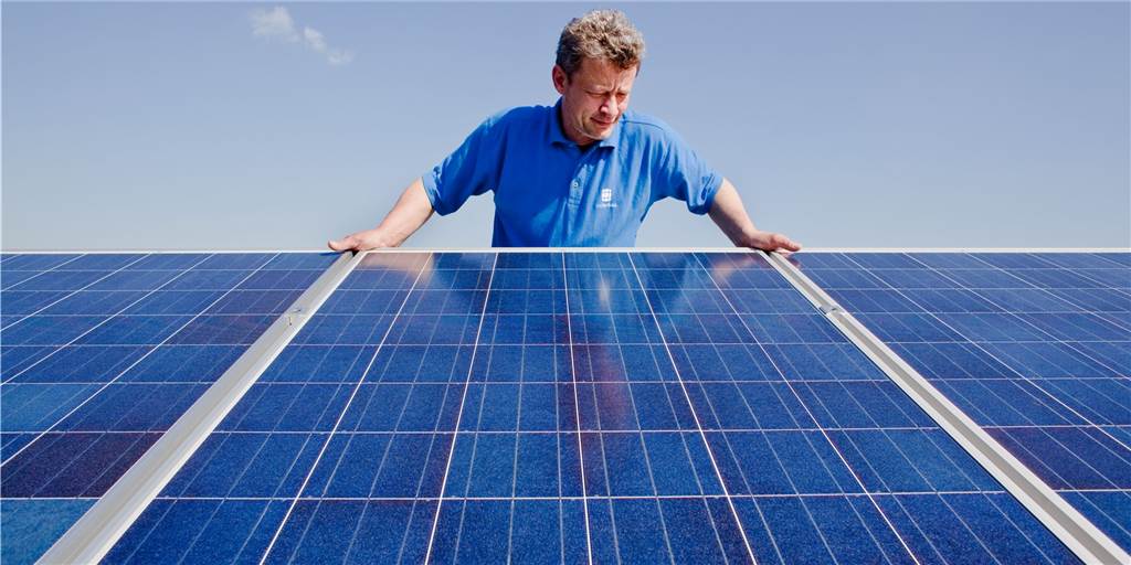 So nutzen Sie möglichst viel grünen Strom zu Hause Ein Techniker überprüft Photovoltaik-Module auf dem Dach eines Hauses.