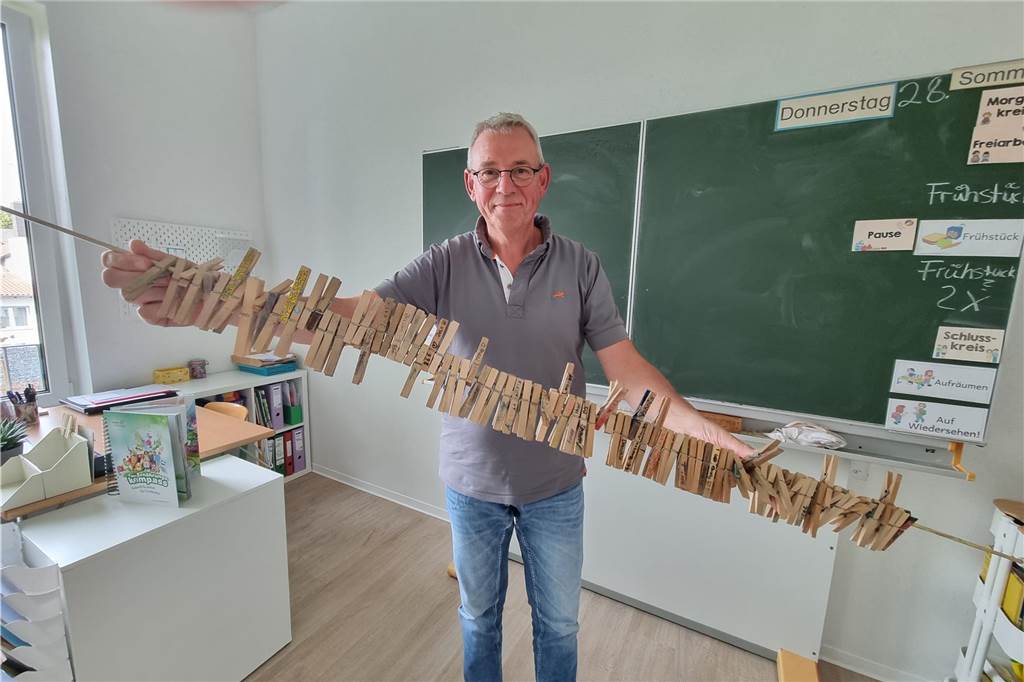 Ein Mann hält eine Gardinenstange mit Wäscheklammern