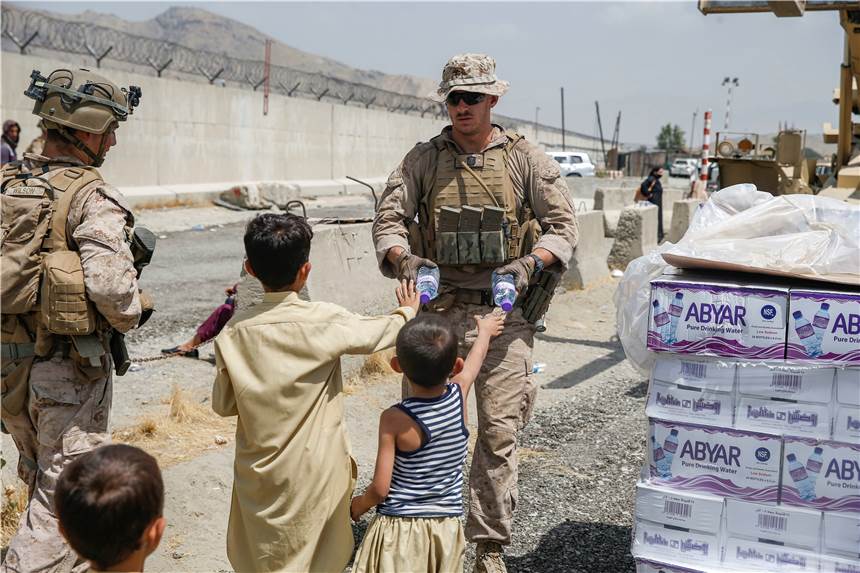 Evakuierungsaktion gerät ins Stocken: 14.000 Menschen warten auf Rettung Auf diesem von den US-Marines zur Verfügung gestellten Bild verteilt ein US-Marinesoldat während der Evakuierung Wasser an Kinder.
