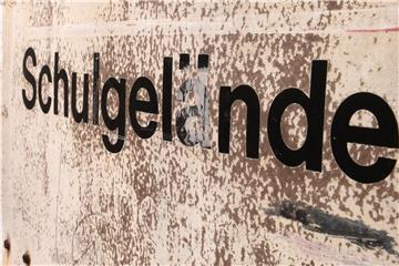 Auf einem Schild vor einem Gymnasium ist der Schriftzug „Schulgelände“ zu sehen. Foto: Hendrik Schmidt/Archiv