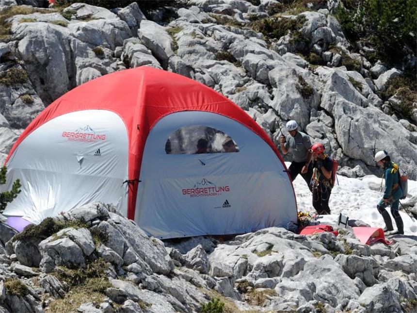 Unglück bei Berchtesgaden: Arzt erreicht Höhlenforscher Auf Höhlenrettungen spezialisierte Helfer aus der Schweiz gehen in der Nähe vom Eingang zur Riesending-Schachthöhle zu einem Schutzzelt für das Rettungsteam. Foto: Tobias Hase
