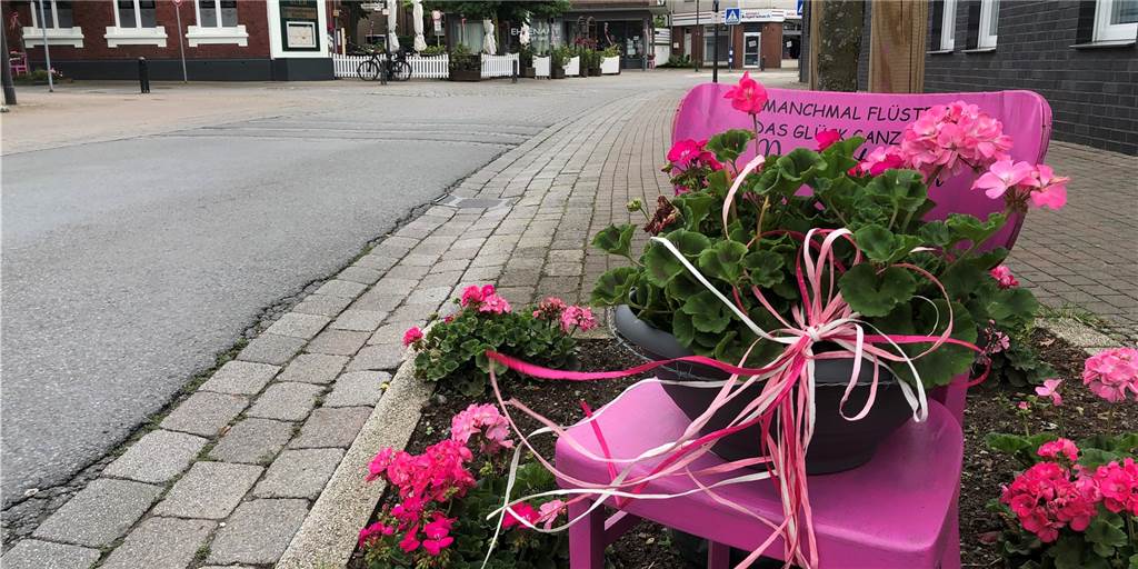 Selmer Altstadt: Was steckt hinter den rosa Blumen und Stühlen? Auf jeden Stuhl steht ein anderer Spruch, der jeweils ein Lächeln beim Leser auslösen soll.