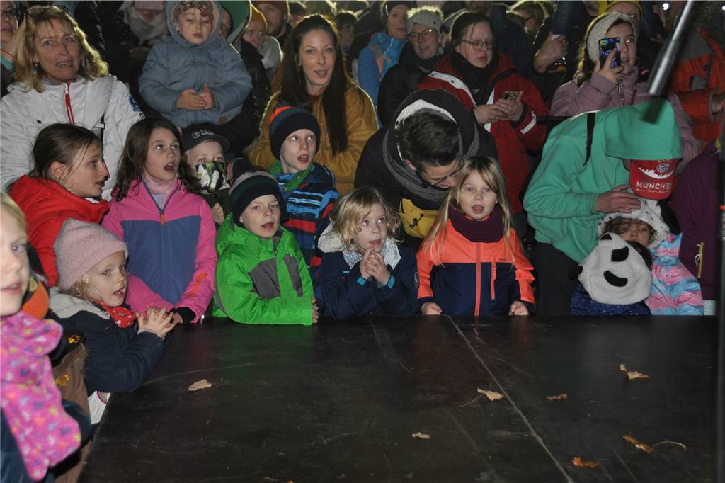 Die Kinder drängen sich vor der Bühne, auf der der Nikolaus steht.